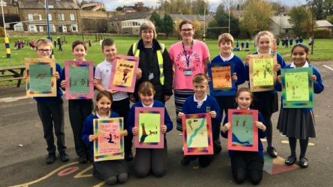 Pupils holding up some artwork they have made