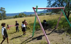 Children playing on a swing at Kwezana School