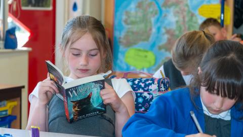 Girl in a classroom reading a book