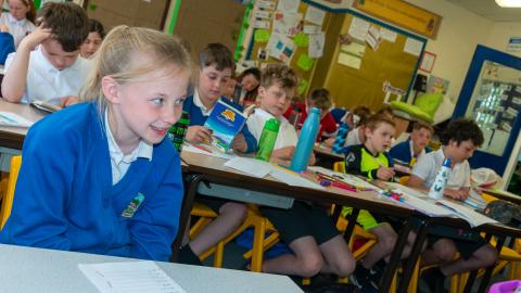 Classroom of pupils, girl in the foreground listening to teacher