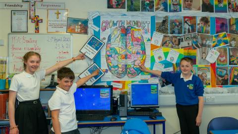 Pupils pointing at a wall display about growth mindset 