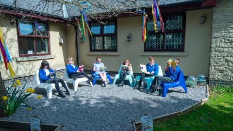 Six pupil sat outside in a quiet reading area 